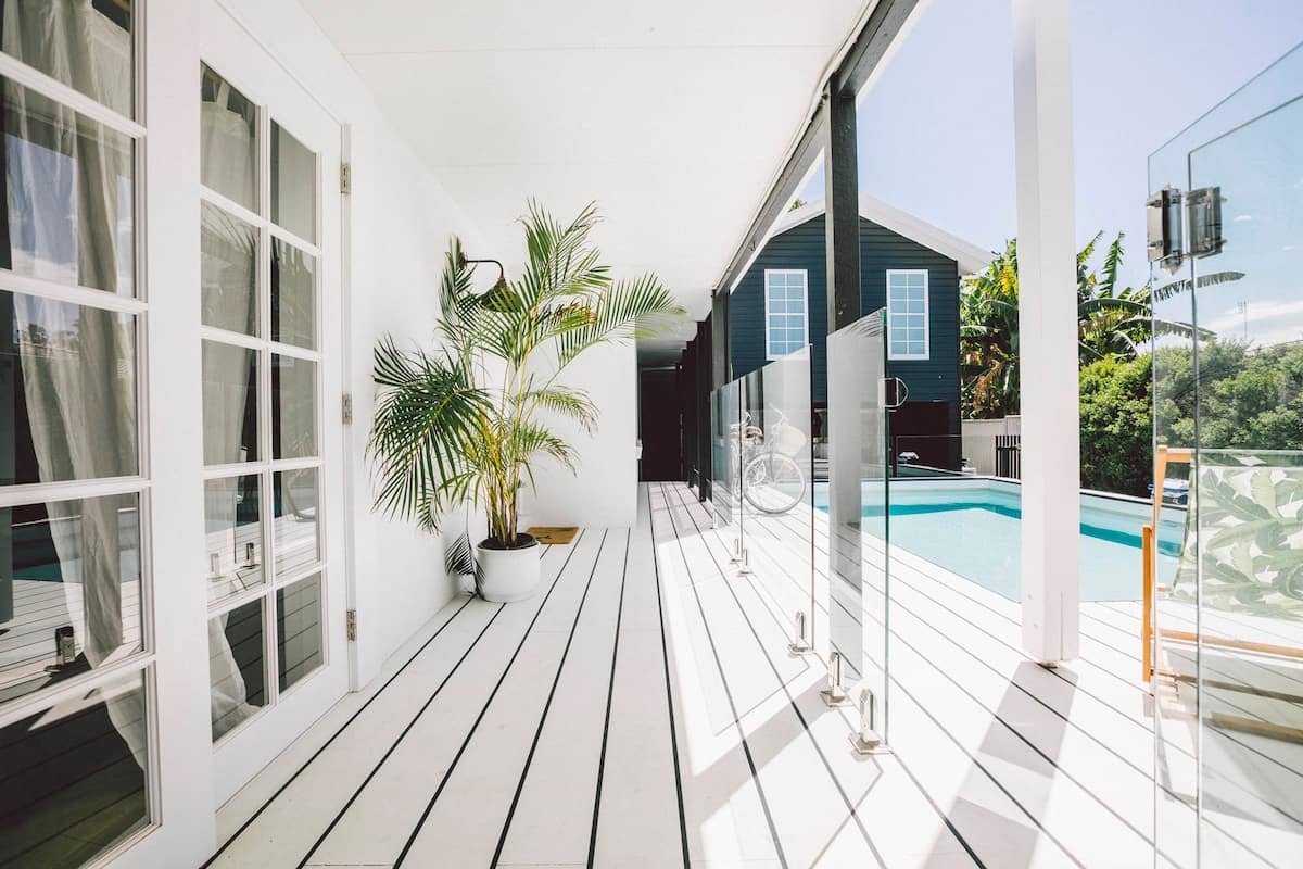 a white verandah area next to a pool