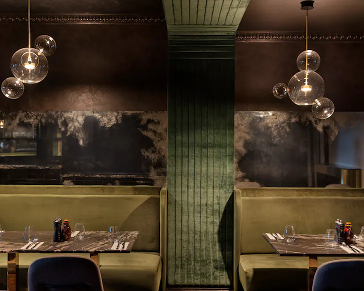 Table settings in sophisticated, moody surrounds with whimsical bubble lights at The Press Club.