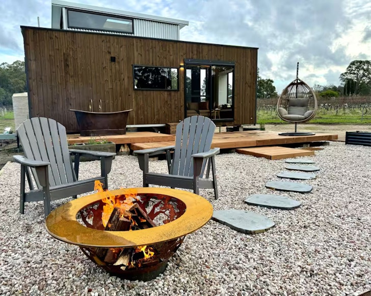 A view of the firepit and bath with house beyond at The Soak at Dalton's Paddock one of the best tiny houses in Australia