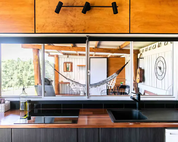 A view to the huge outdoor deck from the kitchen of The Stables Airbnb some of the best Central Coast accommodation