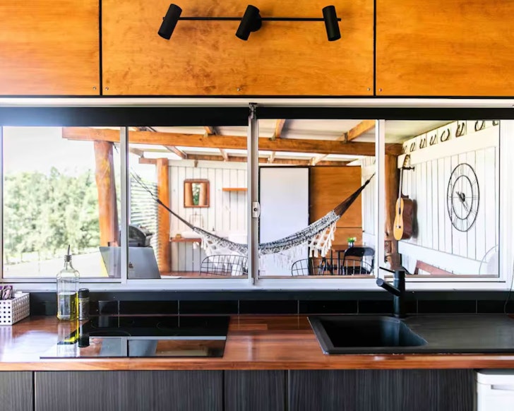 A view to the huge outdoor deck from the kitchen of The Stables Airbnb some of the best Central Coast accommodation