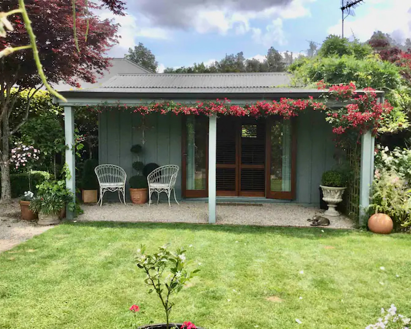 A cute cottage sits in a marvellous garden. 