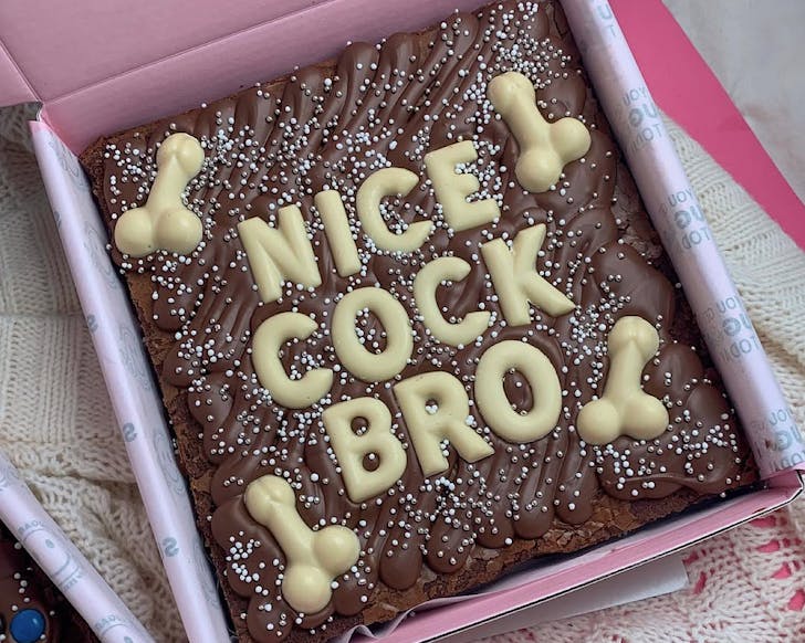 A slab brownie decorated with dicks and the words 'nice cock bro'. 