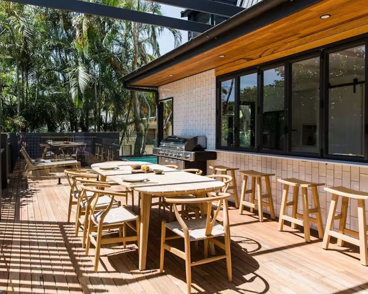 A view of the outdoor barbecue area with dining and pool at The Sunshine Bungalow one of the best Noosa Airbnbs