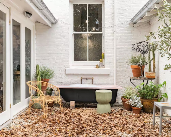 A black and white outdoro bath surrounded by leaves at The Vicarage Victoria