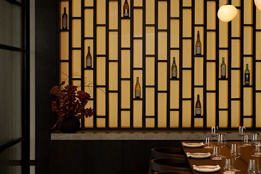 A backlit wall that doubles as a display case for meaningful empty wine bottles dubbed