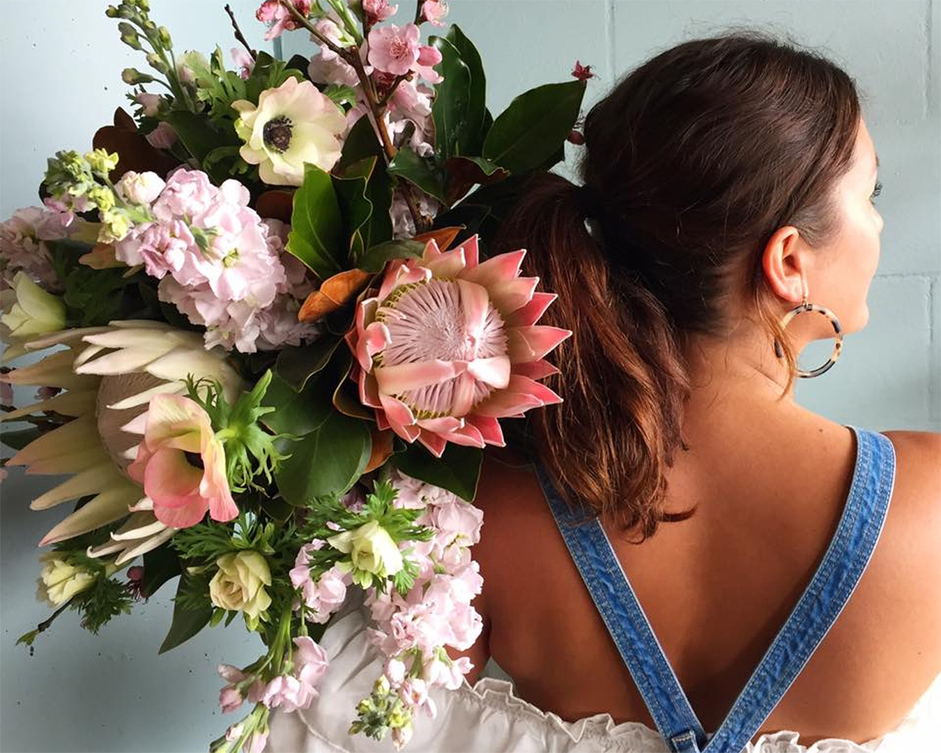 A girl holds a beautiful bouquet over her shoulder at The Botanist. One of Auckland's best flower delivery businesses.