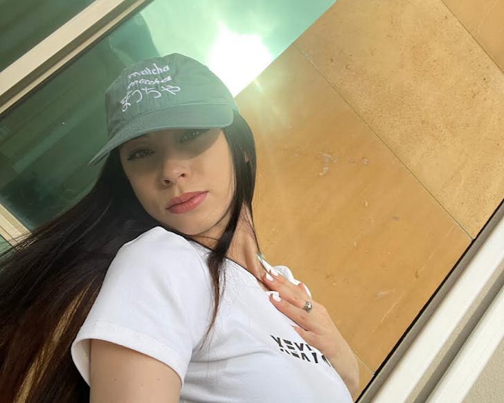 A woman wears a matcha green hued cap, a great Christmas gift for under $50. 