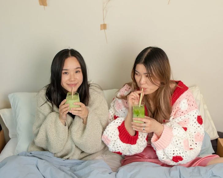 Enna and May in bed drinking matcha. 