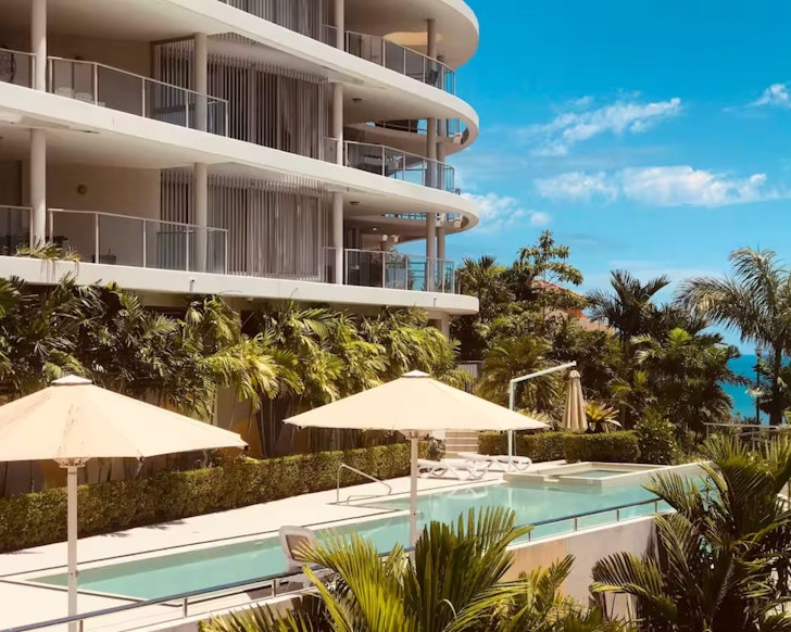An exterior view of the infinity pool and block of Three A Airlie one of the best Airlie Beach Airbnbs