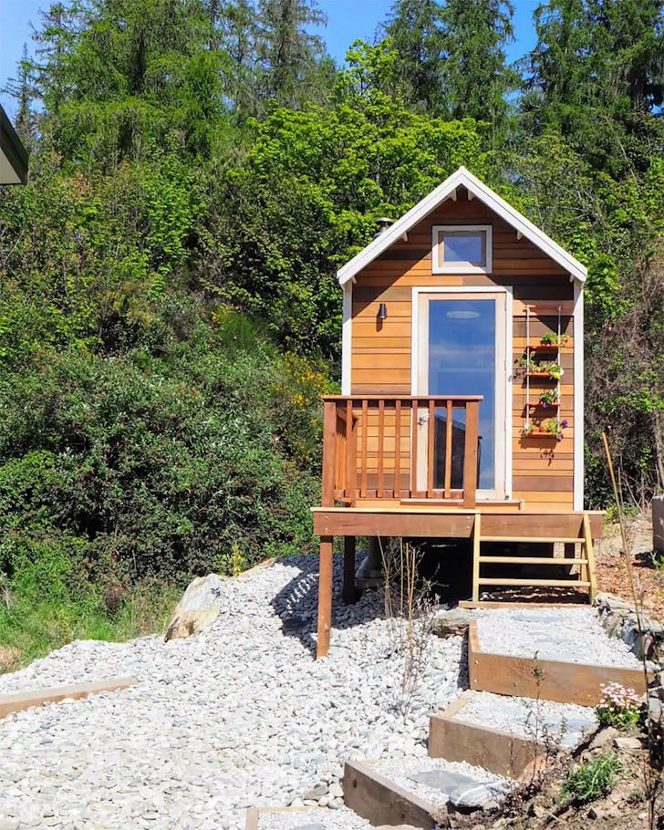 A gorgeous tiny home stands proudly on the shore. One of the best airbnbs in Queenstown.