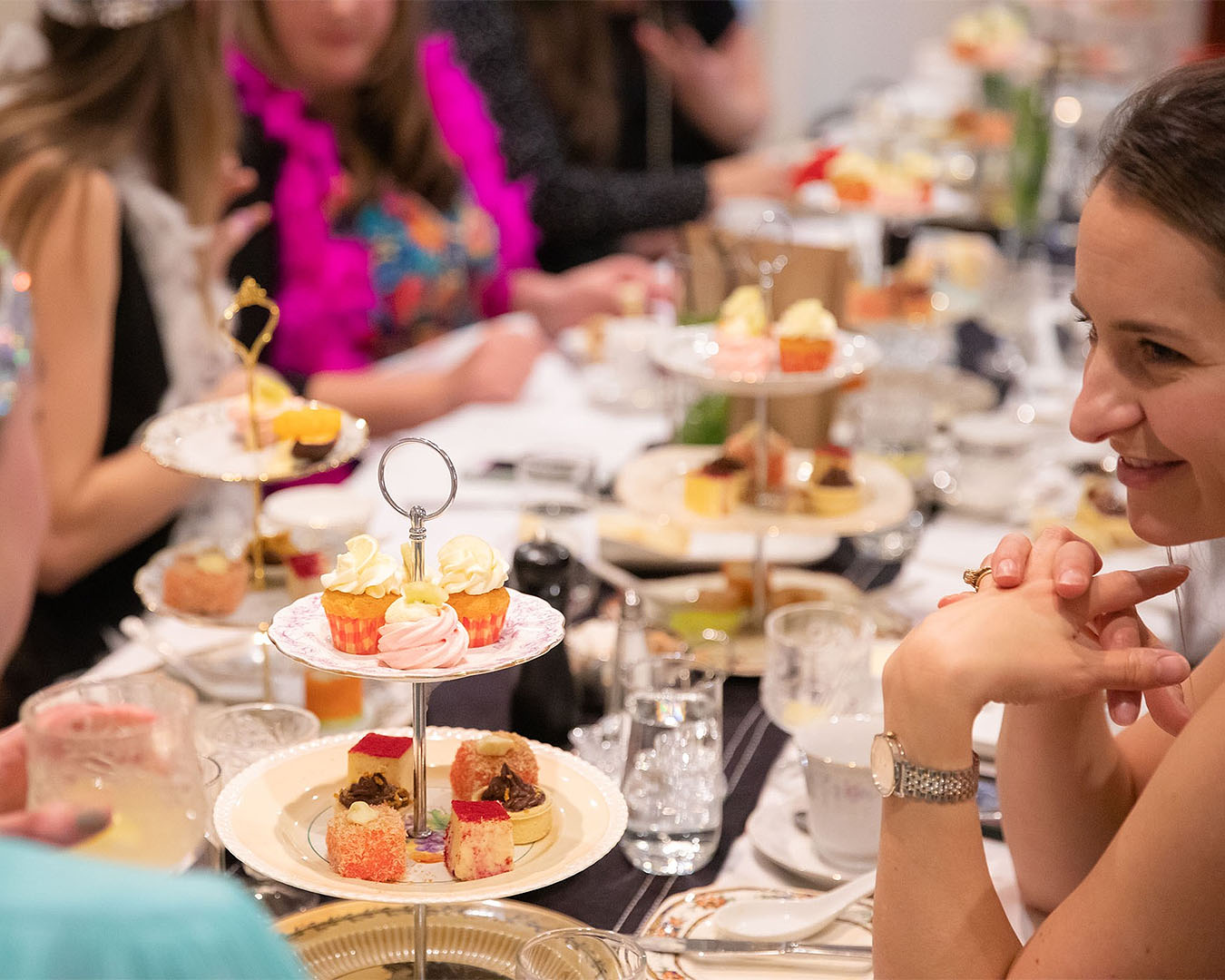 People sit down to enjoy a tipsy high tea dressed up in 1920s outfits at Hotel Debrett.