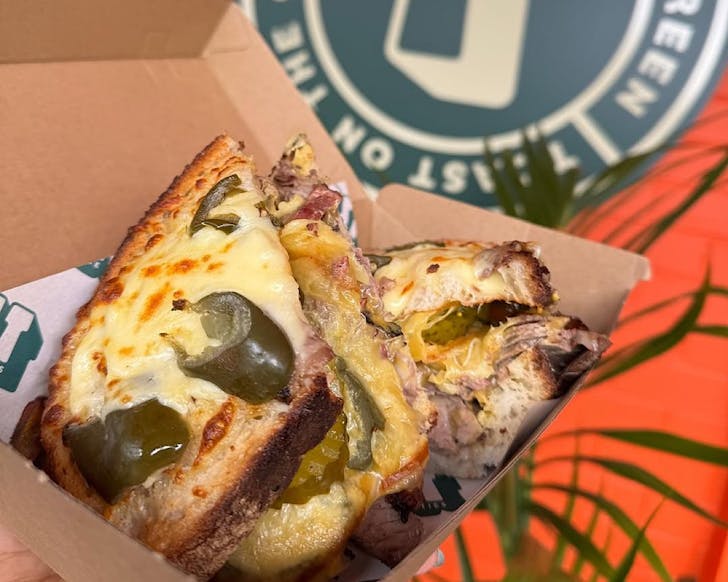A cross-section of one helluva toasted sandwich packed with cheese (on top too) and tuna.