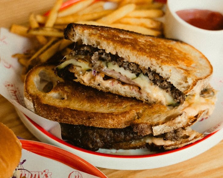 A stack of insane toasted sandwiches and a side of fries at Sammy's Deli & Diner. 