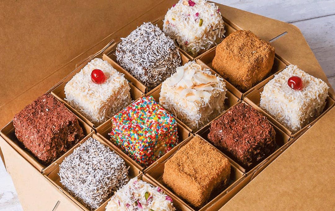A box of different coloured lamingtons. 