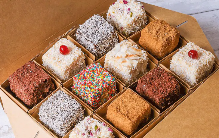 A box of different coloured lamingtons. 