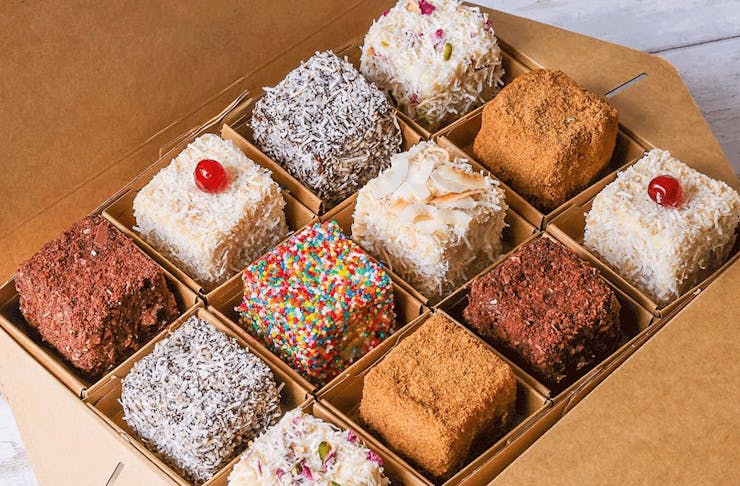 A box of different coloured lamingtons. 