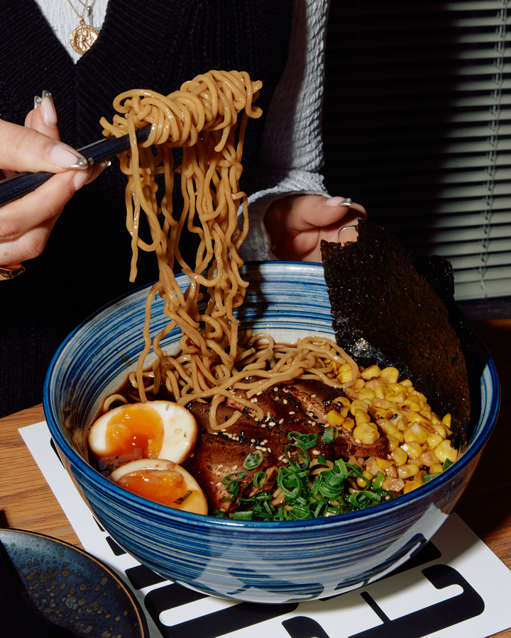 A person pulling up noodles from some of the best ramen in Melbourne.
