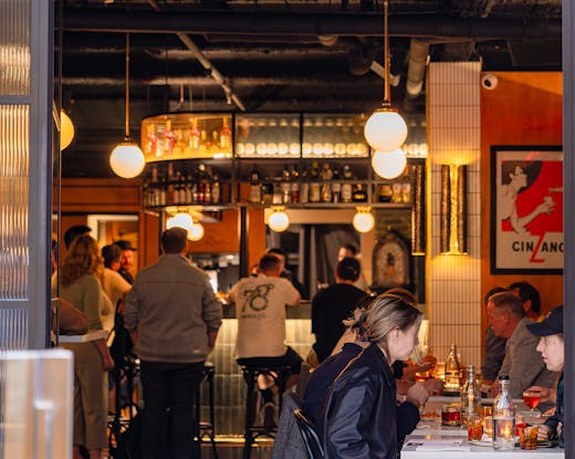 The inside of a bar with people drinking.