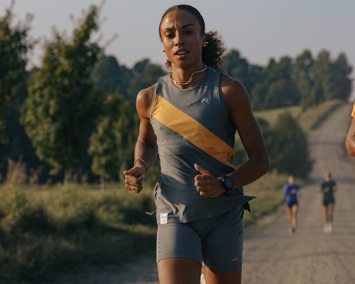 A woman running wearing Tracksmith one of the best activewear brands