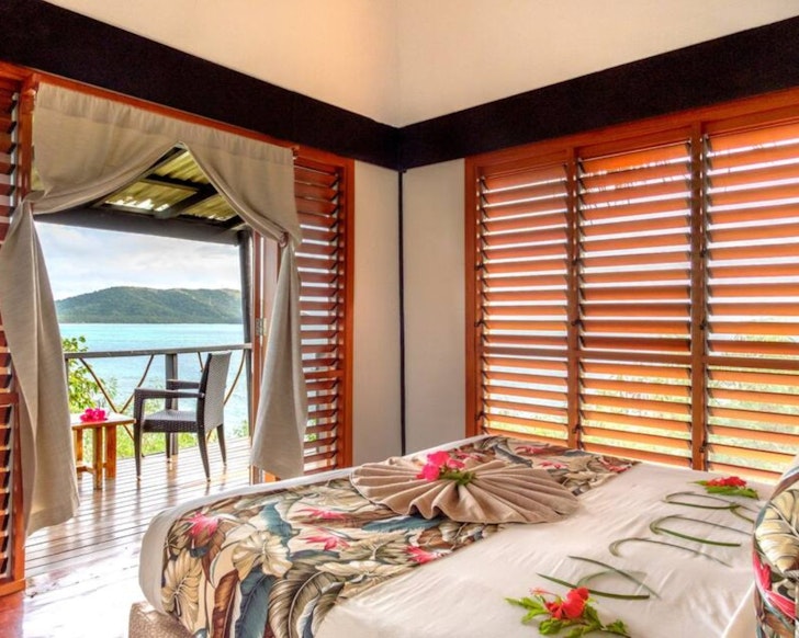 A colourful bedroom overlooking the water at Treetop Bure Fiji