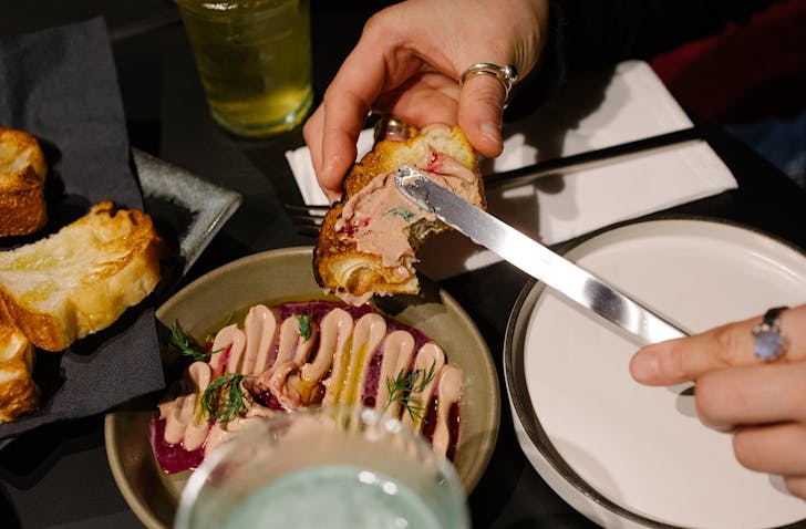 Vicki spreads pate on fluffy toast at truth/dare. 