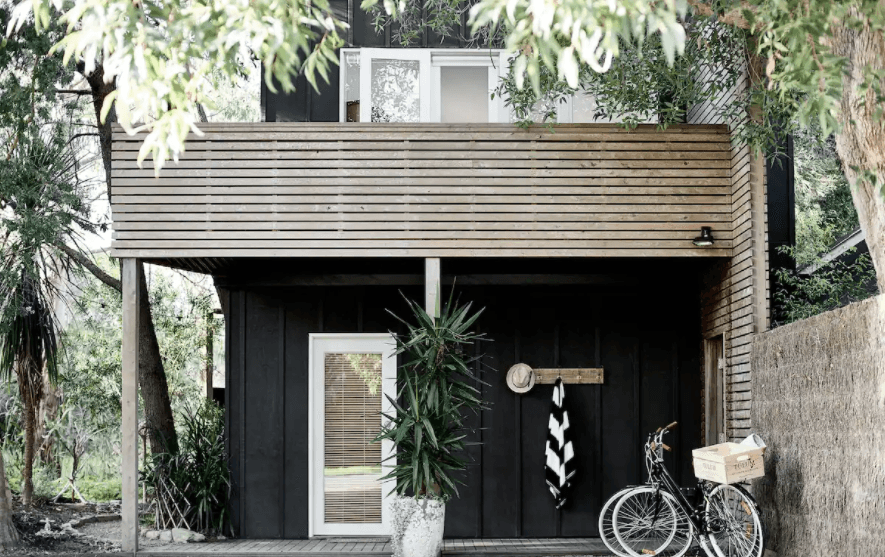 A black-painted beach house at one of the best romantic getaways in Victoria.