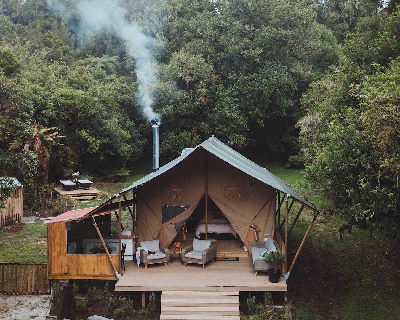 A dreamy glamping cottage set up complete with smoking chimney and twin outdoor baths in the garden. 
