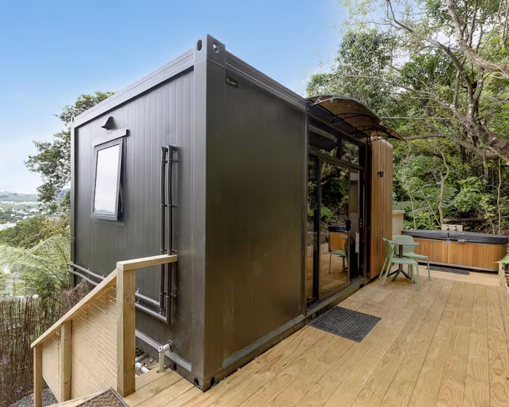 A view of the black tiny home and outdoor bath at Two Peas In A Pod one of the most romantic stays in Wellington