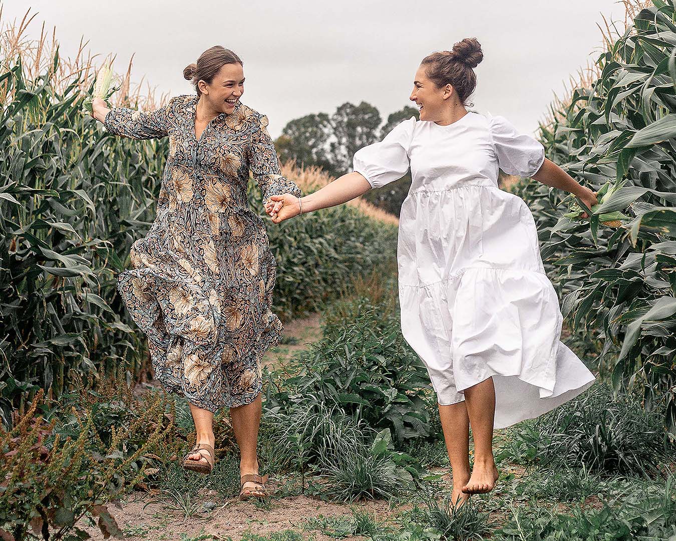 Margo And Rosa skip through a field together happy as clams.