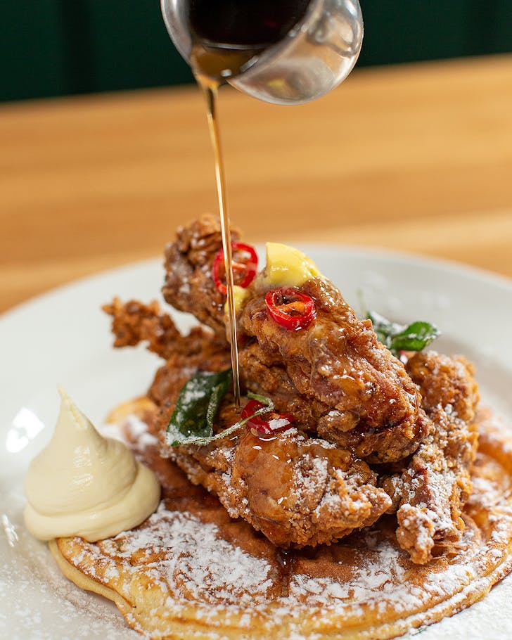 Someone pours maple syrup over a dish at L'affare Newmarket.