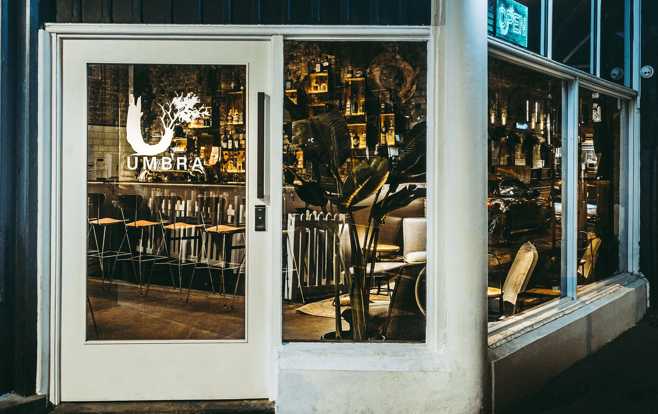 A front door entrance to a bar with a white-painted frame. 