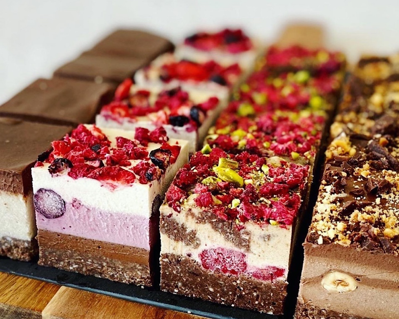 A lineup of multi-layered, multi-coloured raw slices from Unbaked Bakery, one of the best bakery-cafes in New Plymouth. 