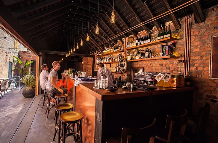 Two people smiling at one of the best CBD bars in Melbourne. 