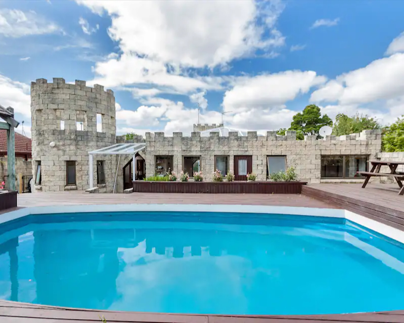 A large blue pool within an airbnb designed as a castle. 