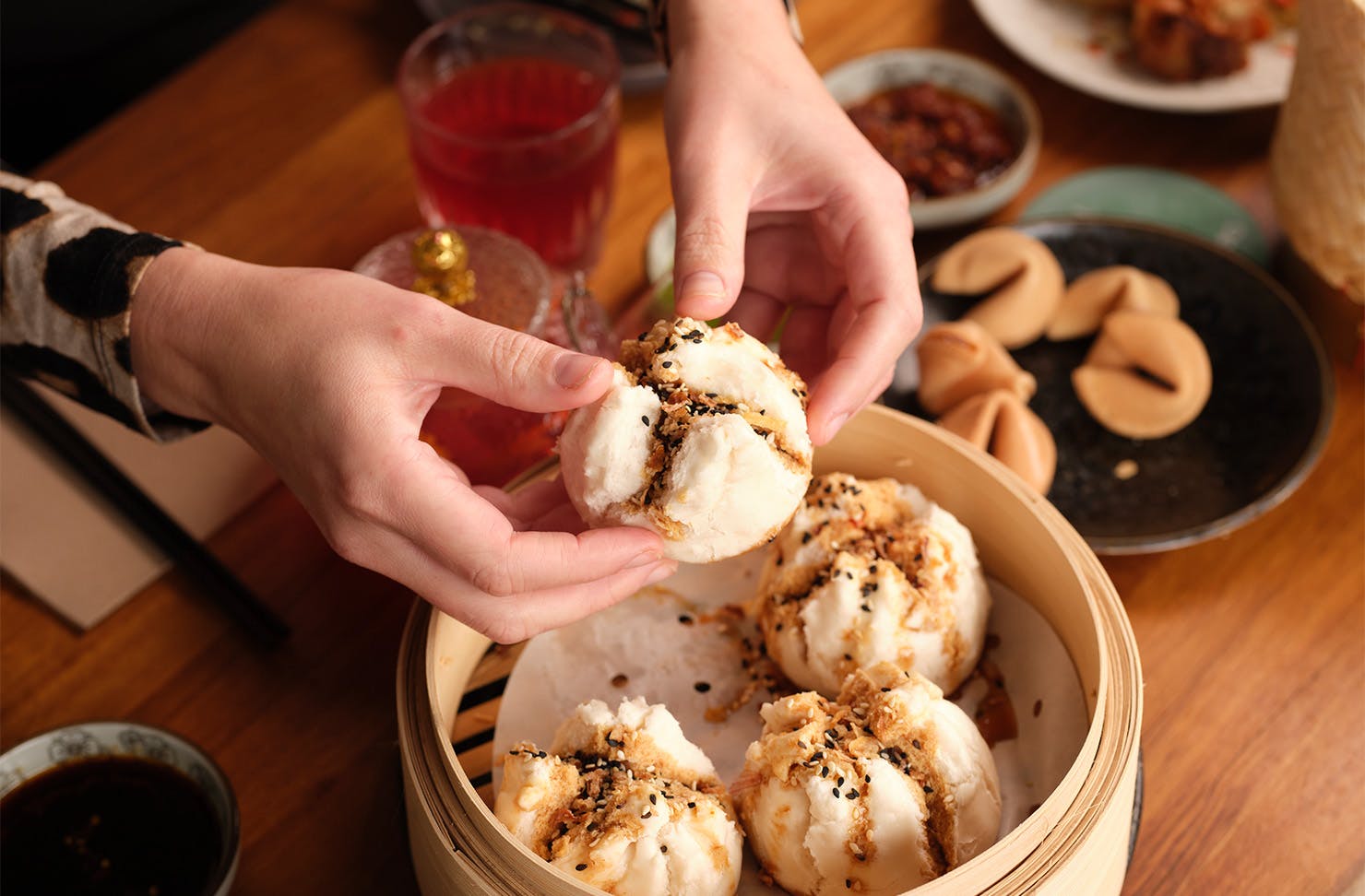 hands grabbing a pork bun and tearing it apart