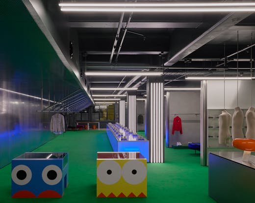 A large clothing boutique with colourful furniture. 