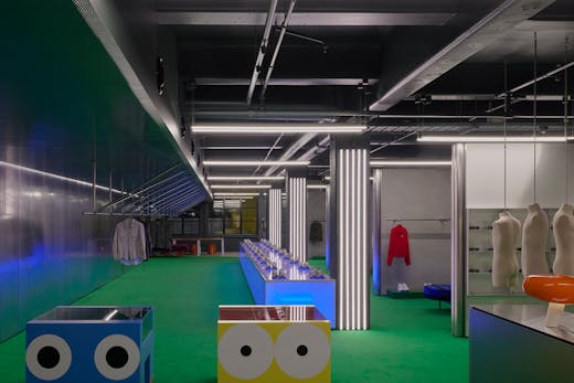 A large clothing boutique with colourful furniture.