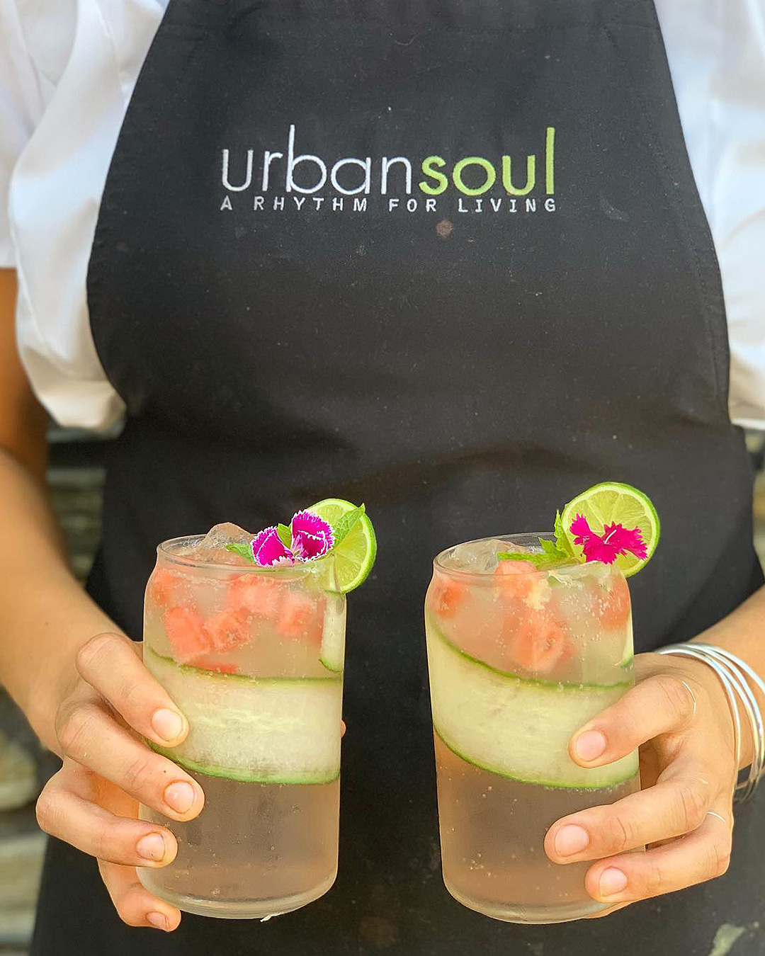 Someone holds two cocktails at Urban Soul Karaka.