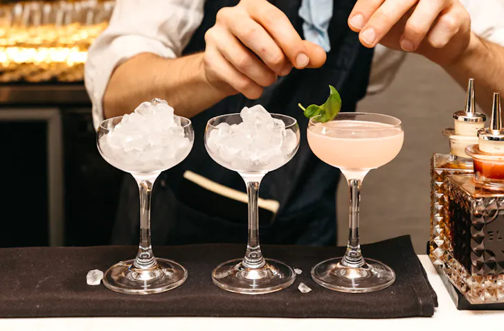 One cocktail glass with a cocktail and two glasses filled with ice.