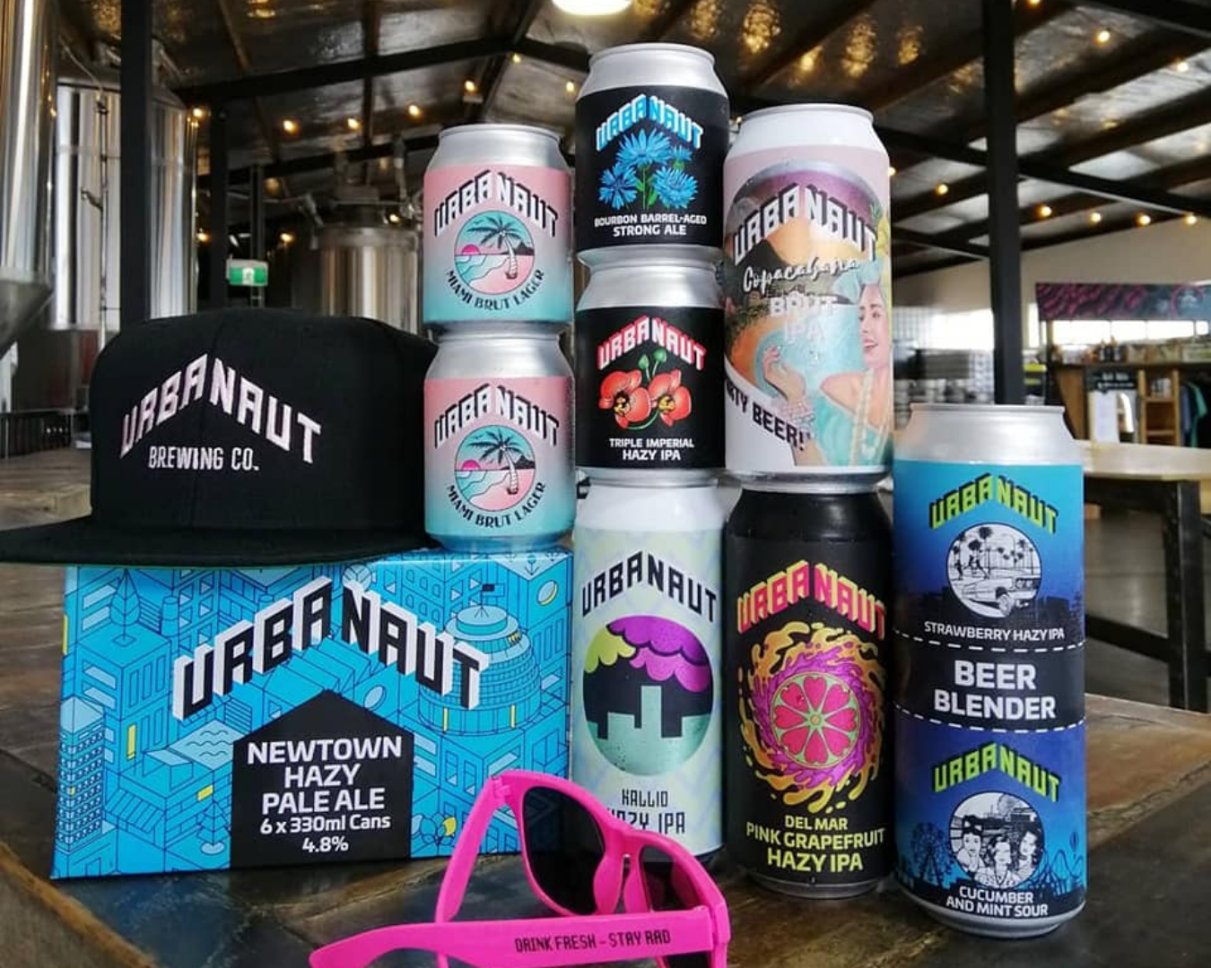 Pink shades, black cap and variety of beer cans by Urbanaut