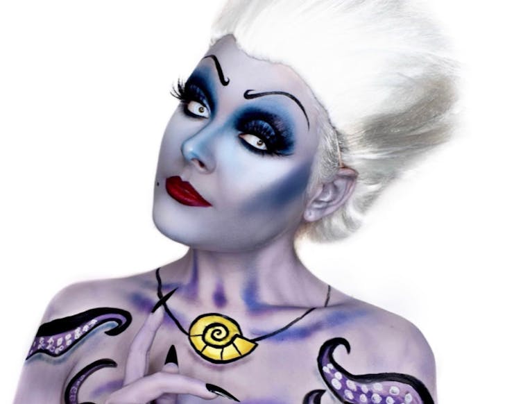 Makeup FX artist Ella Grimmant has purple skin, dramatic eyes and a white wig in an Ursula Halloween costume. 