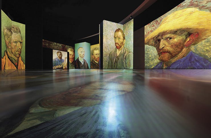 Self portraits of Vincent Van Gogh adorn the walls.