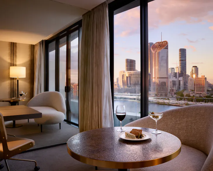 Hotel room with desk and window shaded by curtain