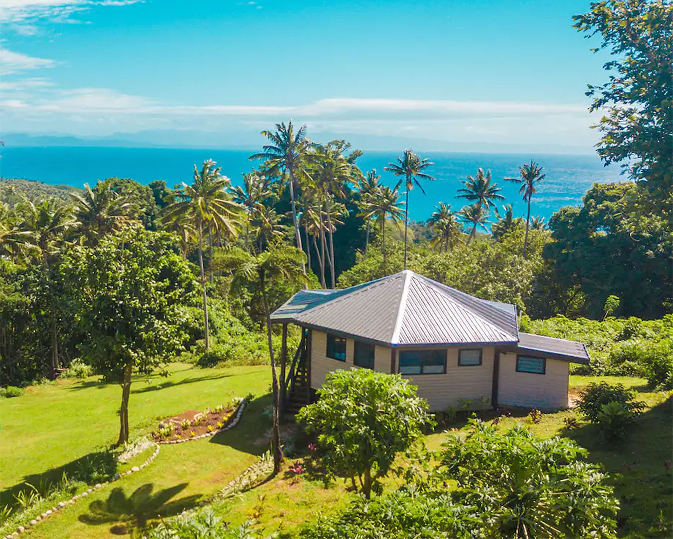 The darling little Vakanananu Retreat with palm trees and the blue sea behind.