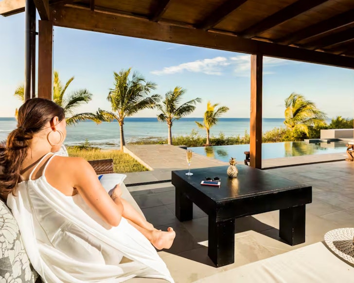 A woman looks out over the pool at Vale-I-Yata Airbnb Fiji