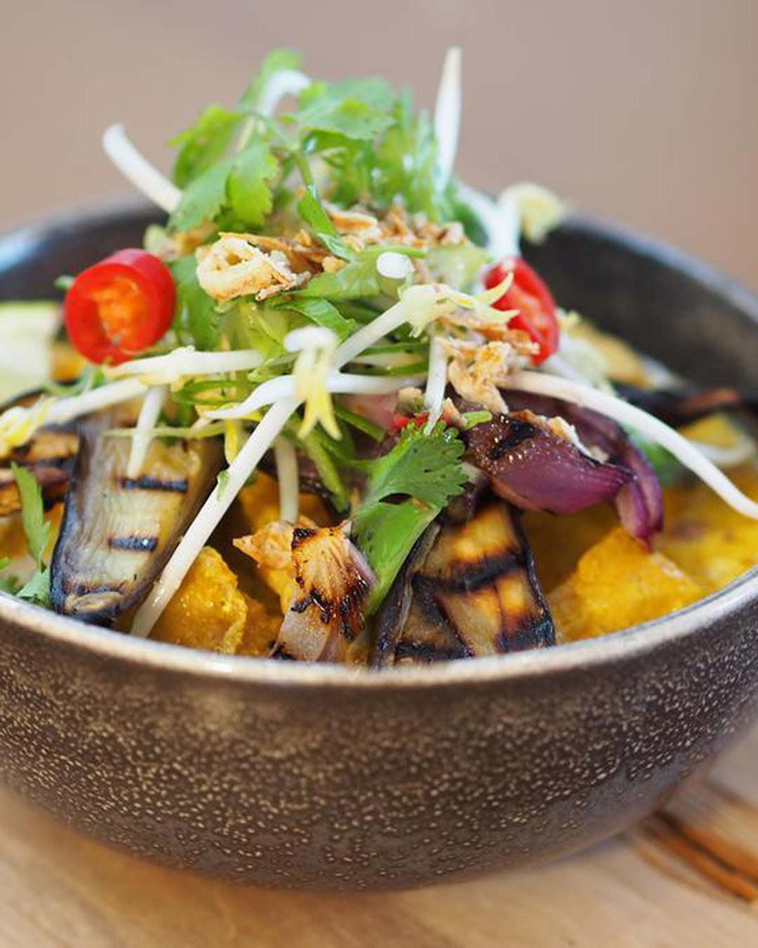 Delicious bowl of healthy looking food with greens and grilled aubergine.