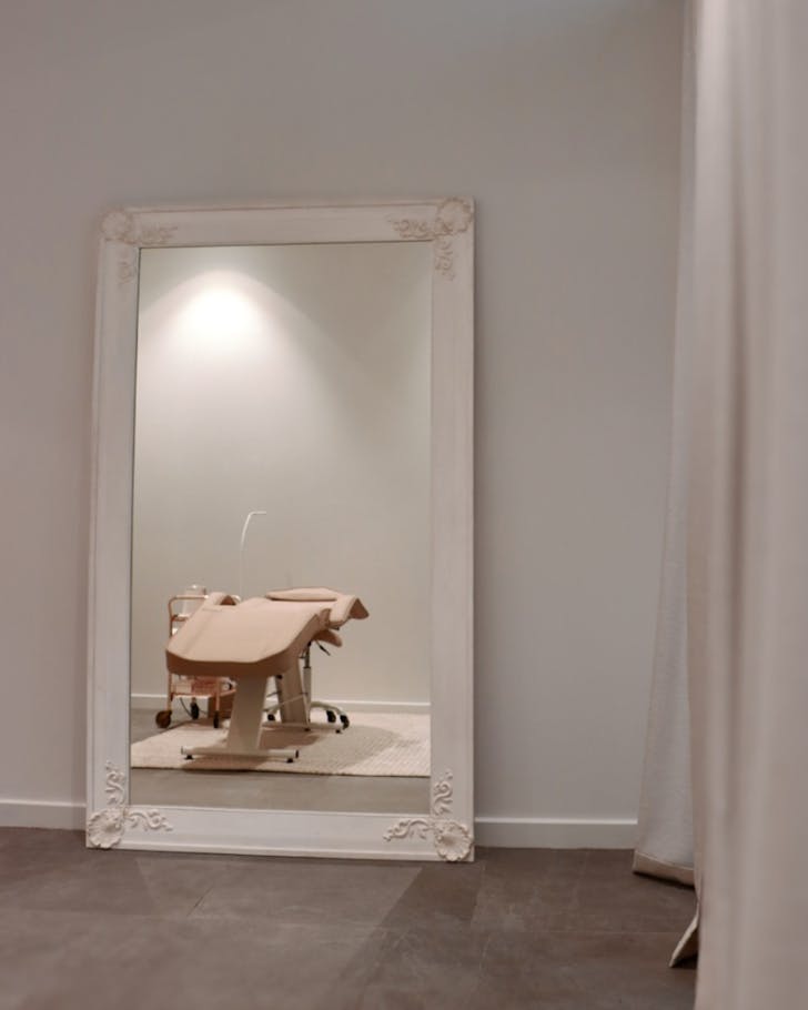 A salon chair pictured in the reflection of an ornate mirror at Velvet Beauty. 