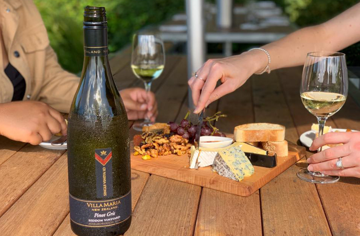 A bottle of Pinot Gris in front of a cheese platter