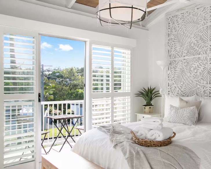 A view of the bedroom with a balcony overlooking Noosa at Villa Coral Tree one of the best Noosa Airbnbs